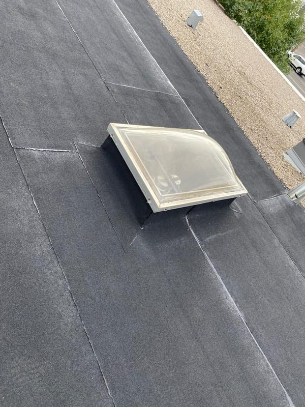 Aged acrylic dome skylight on an SBS flat roof