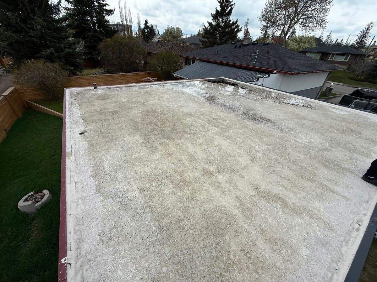 Worn flat roof membrane on a Calgary home before replacement