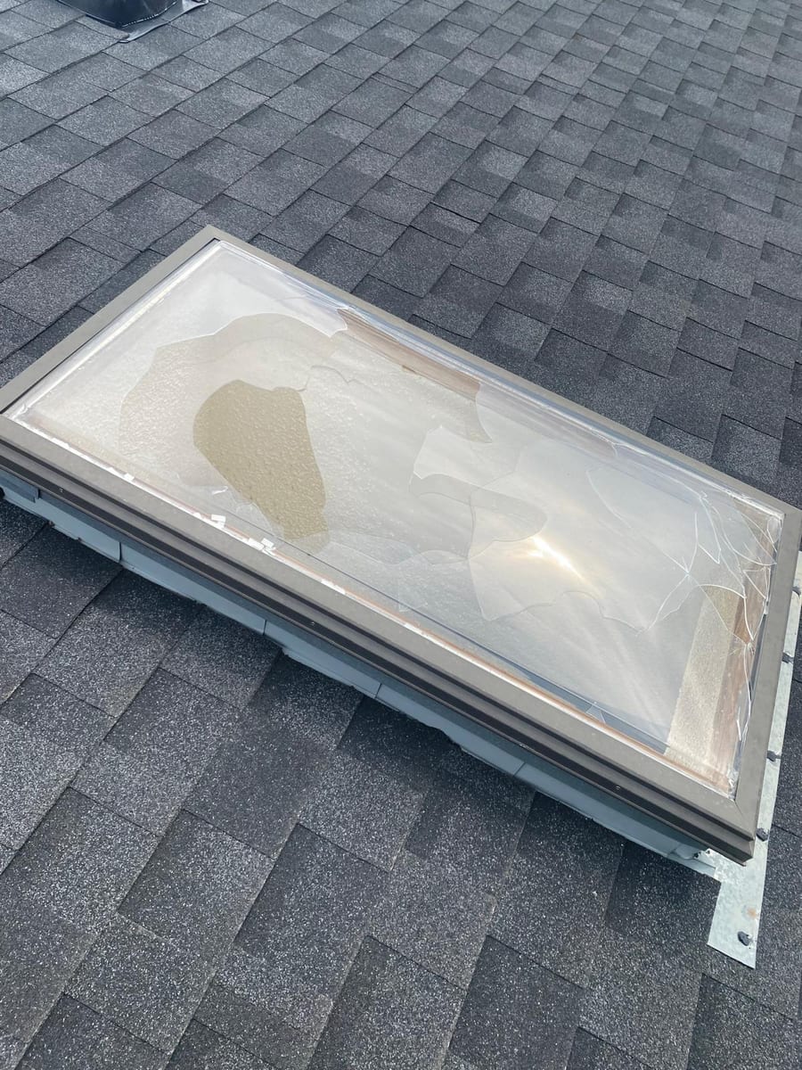 Skylight glazing shattered by hail on a Calgary shingle roof