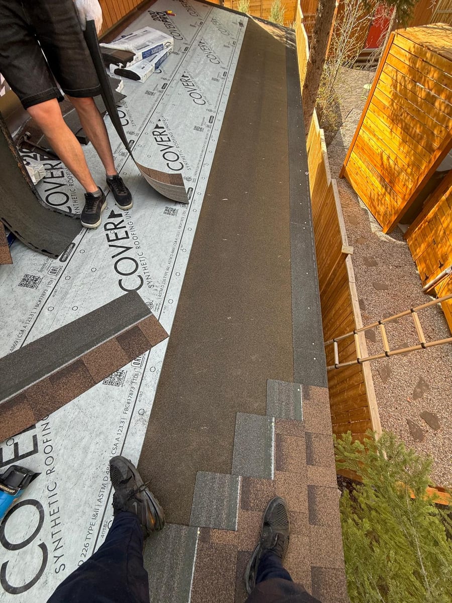 Impact-resistant shingles being installed over synthetic underlayment