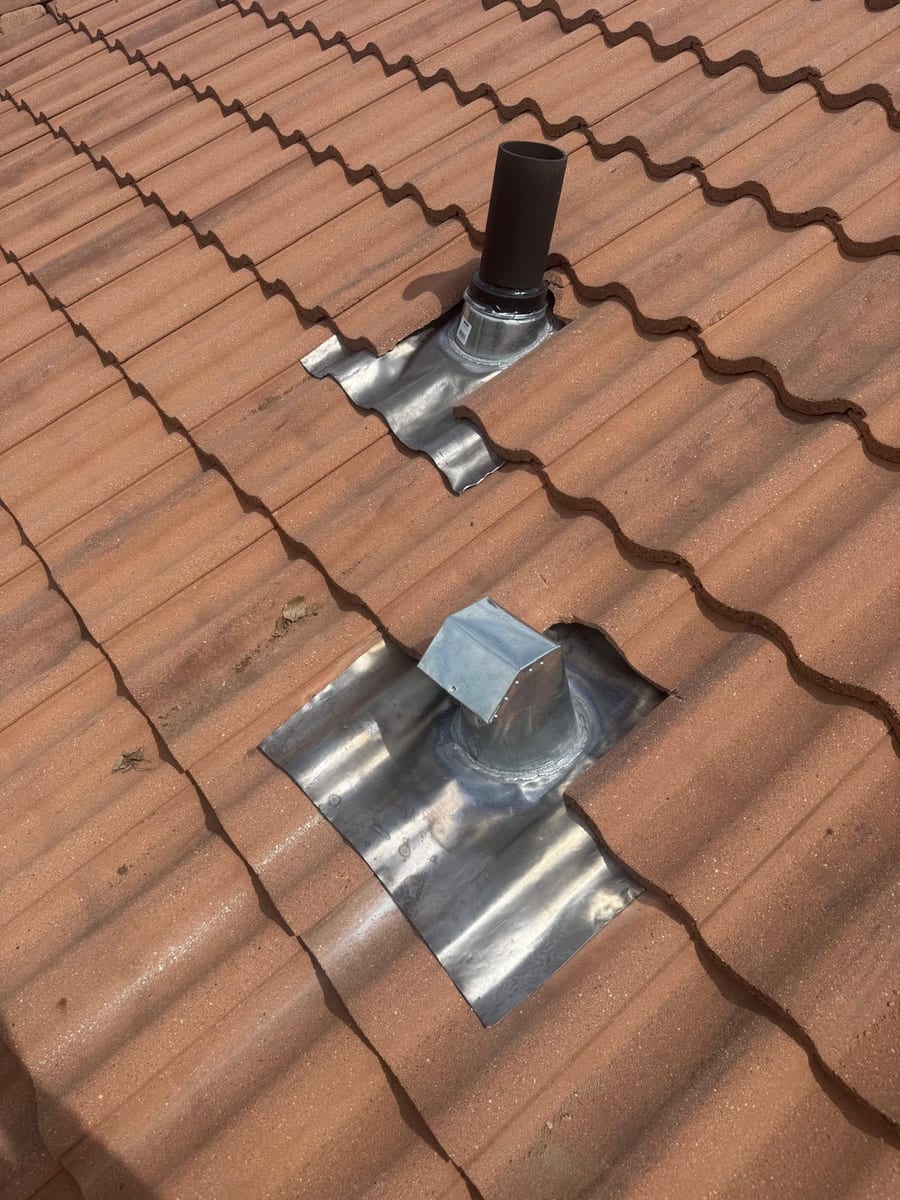 New metal vent boot flashing dressed into a concrete tile roof