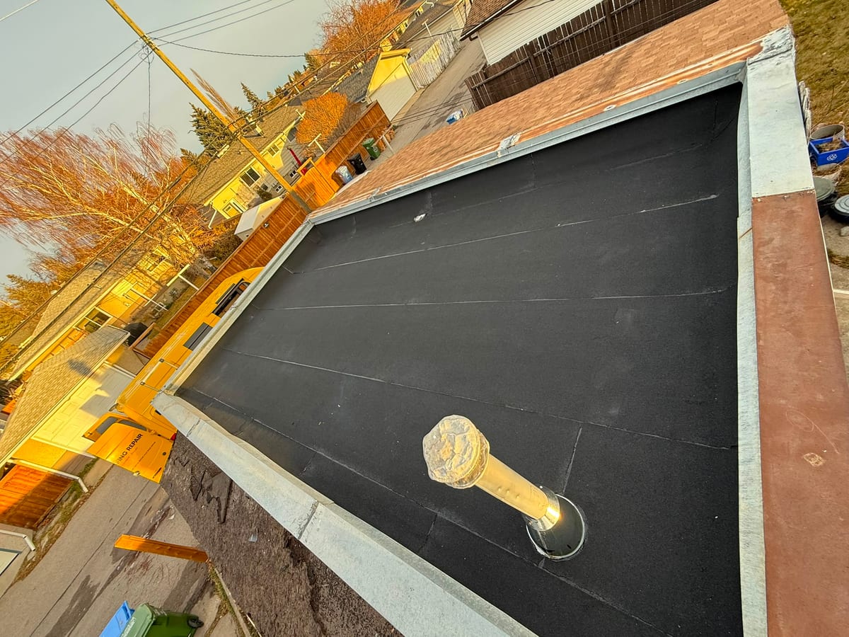 SBS base sheet laid on a garage flat roof around a plumbing stack