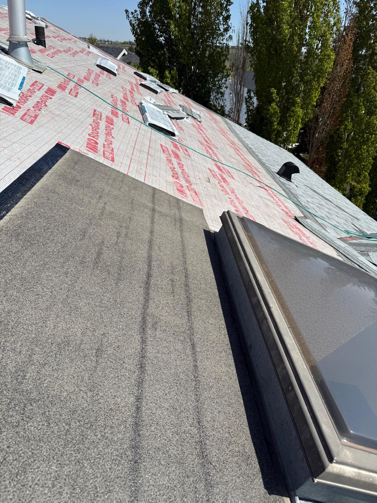 SBS membrane meeting shingle underlayment on one Calgary roof, a low-slope section tied into a sloped one