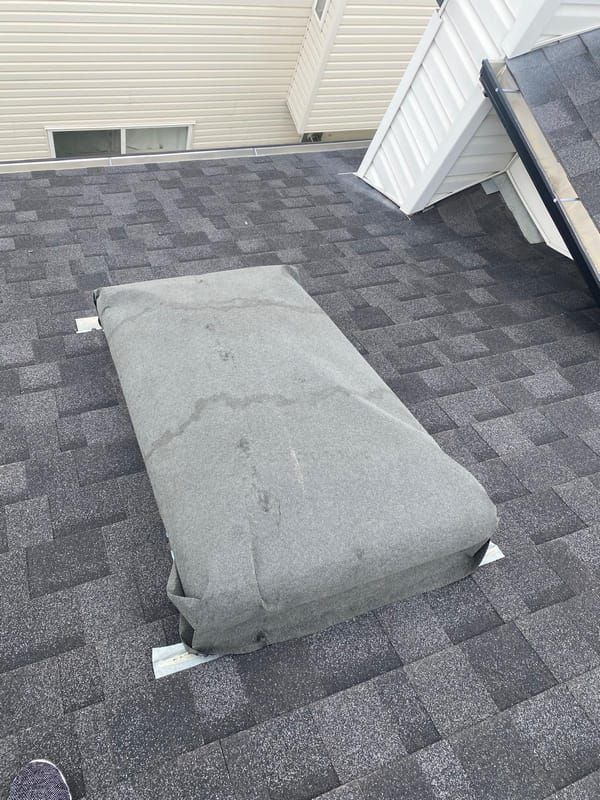 Temporary board-up and membrane cover over a skylight opening